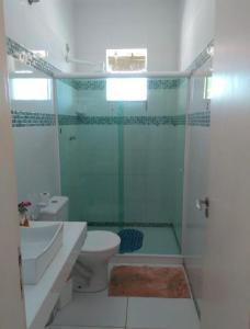 W łazience znajduje się prysznic, toaleta i umywalka. w obiekcie Casa Condomínio Arraial do Cabo w mieście Arraial do Cabo