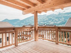 a wooden deck with a view of mountains at AlpenLuxus' CHEZ NOUS with balcony & car park in Fügen