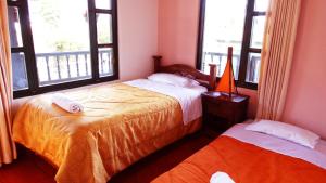 1 dormitorio con 2 camas y 2 ventanas en Cabaña la Cattleya de Villa de Leyva, en Villa de Leyva