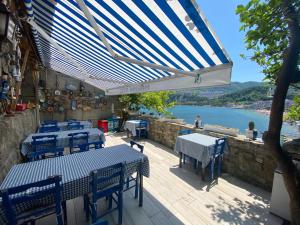 a patio with tables and chairs and a view of the water at Marina Hotel in Amasra