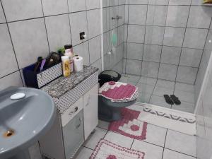 a small bathroom with a sink and a toilet at Casa a Três Quadras da Praia da Cal! Torres in Torres +16 photos