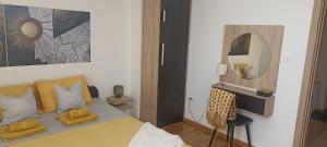 um quarto com uma cama com almofadas amarelas e um espelho em Apartman Blagojevic Hill em Arandjelovac