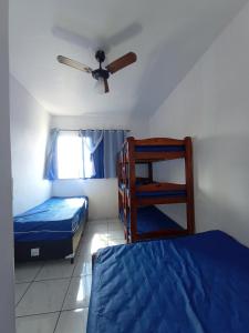 1 dormitorio con 2 camas y ventilador de techo en Frente ao mar na Praia Grande, en Praia Grande