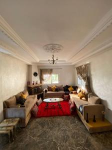 a living room with couches and a table in it at Vila Haja - Beautiful Farmhouse with a Private Pool! in Imouzzer Kandar