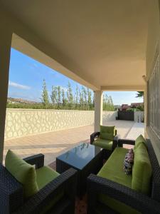une terrasse avec deux canapés, une table et des chaises dans l'établissement Vila Haja - Beautiful Farmhouse with a Private Pool!, à Imouzzer du Kandar