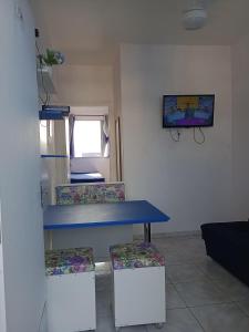 una mesa azul y 2 sillas en una habitación en Frente ao mar na Praia Grande, en Praia Grande