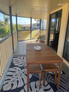 d'une terrasse avec une table en bois sur un balcon. dans l'établissement Studio Apartment, à Bargara