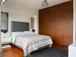 a bedroom with a large bed and wooden cabinets at Book in SI1 - Lima in Lima