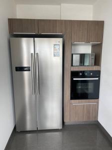 a kitchen with a stainless steel refrigerator and a microwave at Book in SI1 - Lima in Lima