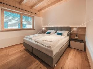 AlpenLuxus' ZILLERHEART with balcony & car park في فوغين: غرفة نوم بسرير كبير في غرفة
