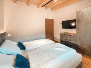 two twin beds in a room with a television at ZILLERHEART - AlpenLuxus Collection in Fügen