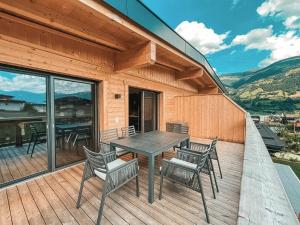 菲根的住宿－AlpenLuxus' ZILLERHEART with balcony & car park，木制甲板上配有桌椅