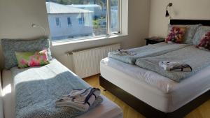 a bedroom with two beds and a window at Olafsvik Guesthouse in Ólafsvík