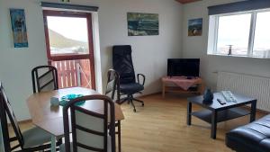 a living room with a couch and a table and chairs at Olafsvik Guesthouse in Ólafsvík