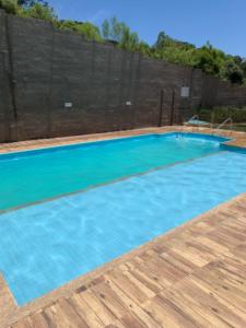 a large blue swimming pool with a wooden deck at Apto com linda vista in Campo Largo