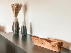 une table avec deux vases et deux chaussures dessus dans l'établissement ISANORA - AlpenLuxus Collection, à Fügen