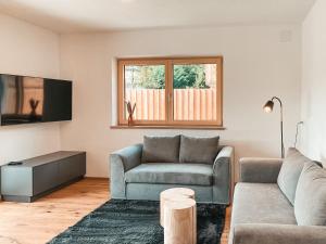 un salon avec un canapé et une télévision dans l'établissement ISANORA - AlpenLuxus Collection, à Fügen