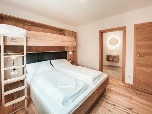 ein Schlafzimmer mit einem Etagenbett mit weißer Bettwäsche in der Unterkunft AlpenLuxus' ISANORA with garden & car park in Fügen