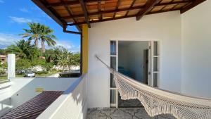 una hamaca en el balcón de una casa en Kalug - Guest House com 3 quartos em Condomínio na Praia dos Milionários, en Ilhéus
