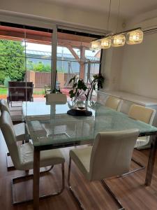 comedor con mesa de cristal y sillas en Apartmán s Whirlpoolem a klimatizací Brno 