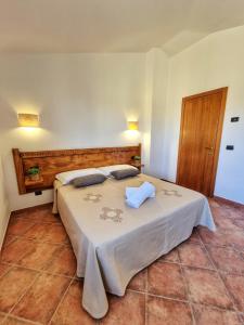 a bedroom with a large bed with two pillows on it at Domos de Ammentos in Tortolì