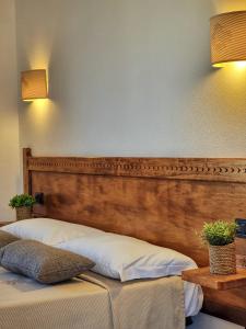 a bedroom with a bed with a wooden headboard at Domos de Ammentos in Tortolì