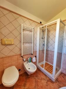 a bathroom with a shower and a toilet and a sink at Domos de Ammentos in Tortolì