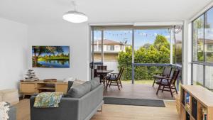 ein Wohnzimmer mit einem Sofa und einem großen Fenster in der Unterkunft Modern Pet Friendly Family Retreat in Bongaree