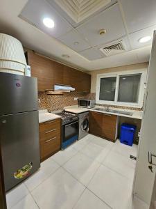 a kitchen with a stainless steel refrigerator and a dishwasher at SKY 9 Hostel in Dubai