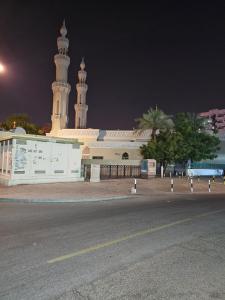 a large white building with a clock tower at night at SKY 9 Hostel in Dubai