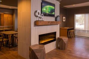 a living room with a fireplace and a tv at SpringHill Suites Herndon Reston in Herndon