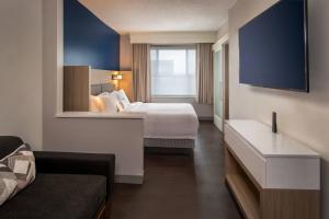 a hotel room with a bed and a couch at SpringHill Suites Herndon Reston in Herndon