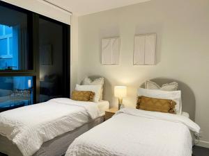 een slaapkamer met 2 bedden en een raam bij Modern 2 Bedrooms FREE Carpark in Melbourne