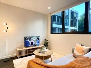 een woonkamer met een bank en een tv bij Modern 2 Bedrooms FREE Carpark in Melbourne