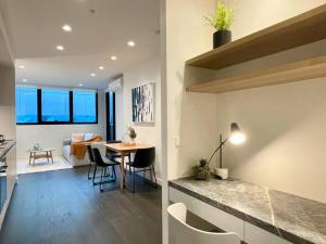 een keuken en een woonkamer met een tafel en stoelen bij Modern 2 Bedrooms FREE Carpark in Melbourne
