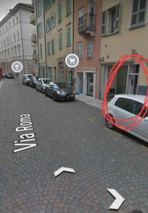 ein roter Kreis auf einer Straße mit geparkten Autos in der Unterkunft Cavour Home in Trient