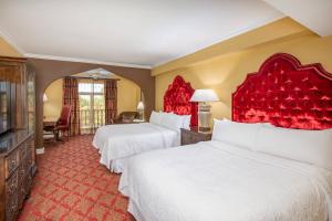 two beds in a hotel room with red accents at Casa Monica Resort & Spa, Autograph Collection in St. Augustine