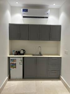 a kitchen with a sink and a refrigerator at سويت إم للأجنحة الفندقية in AR Rummanah