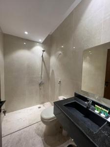 uma casa de banho com um WC, um lavatório e um chuveiro em سويت إم للأجنحة الفندقية em AR Rummanah