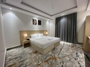 a hotel room with a bed and a window at سويت إم للأجنحة الفندقية in AR Rummanah