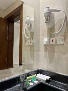 uma casa de banho com um lavatório e um espelho em سويت إم للأجنحة الفندقية em AR Rummanah