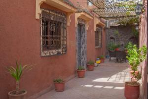 um pátio vazio com vasos de plantas e uma cerca em Riad Dar Fadma em Ouarzazate