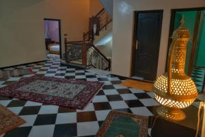 a room with a checkered floor with a lamp in the middle at Riad Dar Fadma in Ouarzazate