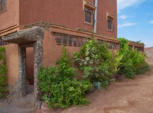 a building with potted plants on the side of it at Riad Dar Fadma in Ouarzazate