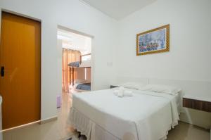 a white bedroom with a bed and a picture on the wall at Hotel Penha in Penha