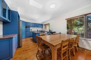 a kitchen with a wooden table and blue cabinets at 11 Guest, Xbox, Netflix, Close to Shops & Parks in Kingston 