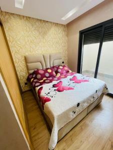 a bedroom with a large bed with pink flowers on it at Studio nouveaux, bien situé in Casablanca
