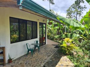eine Terrasse eines Hauses mit 2 Stühlen und einem Tisch in der Unterkunft Finca Soley in Tucurrique