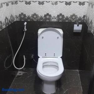 a bathroom with a white toilet in a black wall at Dormitory bed space in a shared room in Sharjah