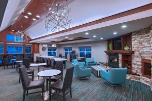 a lobby with tables and chairs and a fireplace at Residence Inn Columbia in Columbia